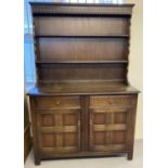An Ercol style dark wood dresser with 2 drawer, 2 door cupboard base. Shaped top with 2 shelves.
