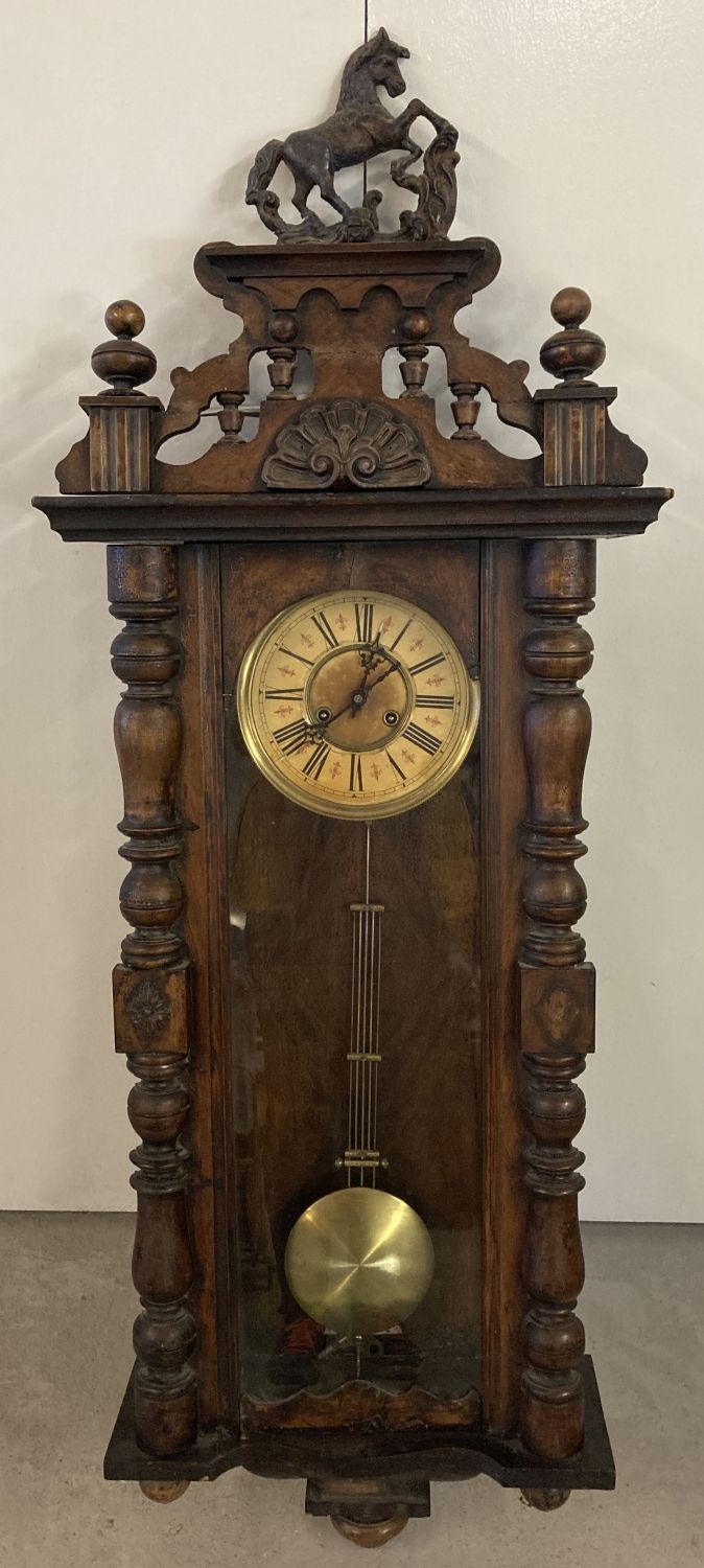 An antique dark wood cased Vienna style wall clock with glass panelled case.