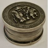 A Chinese white metal rouge pot with figural detail to lid and Greek key design to rim.