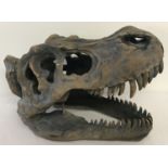 A modern ornamental T-Rex skull ornament with fixings for wall hanging.