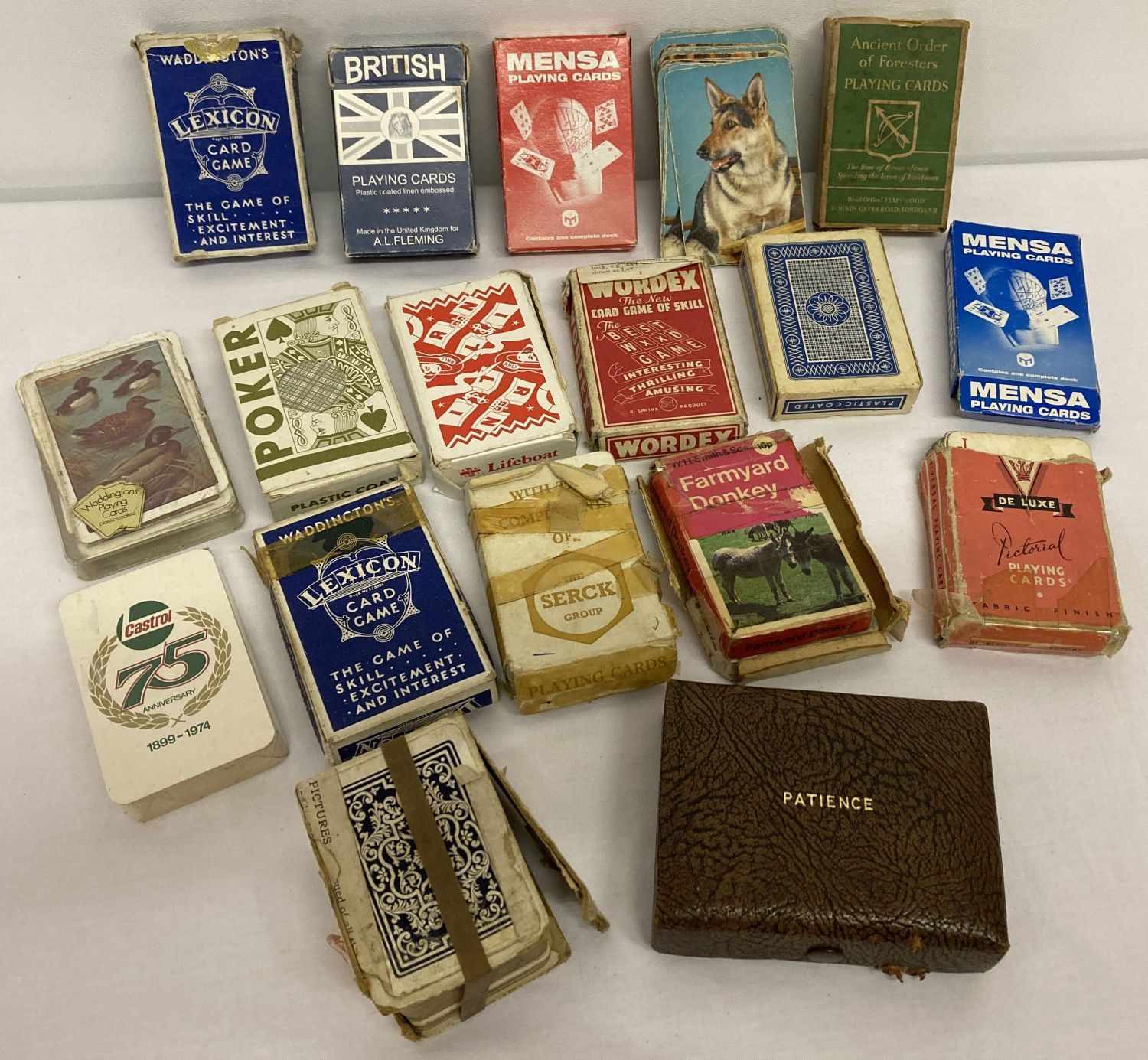 A collection of vintage playing cards, mostly boxed.