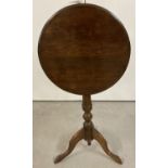 An Edwardian circular tip top table raised on tripod feet with turned pedestal.