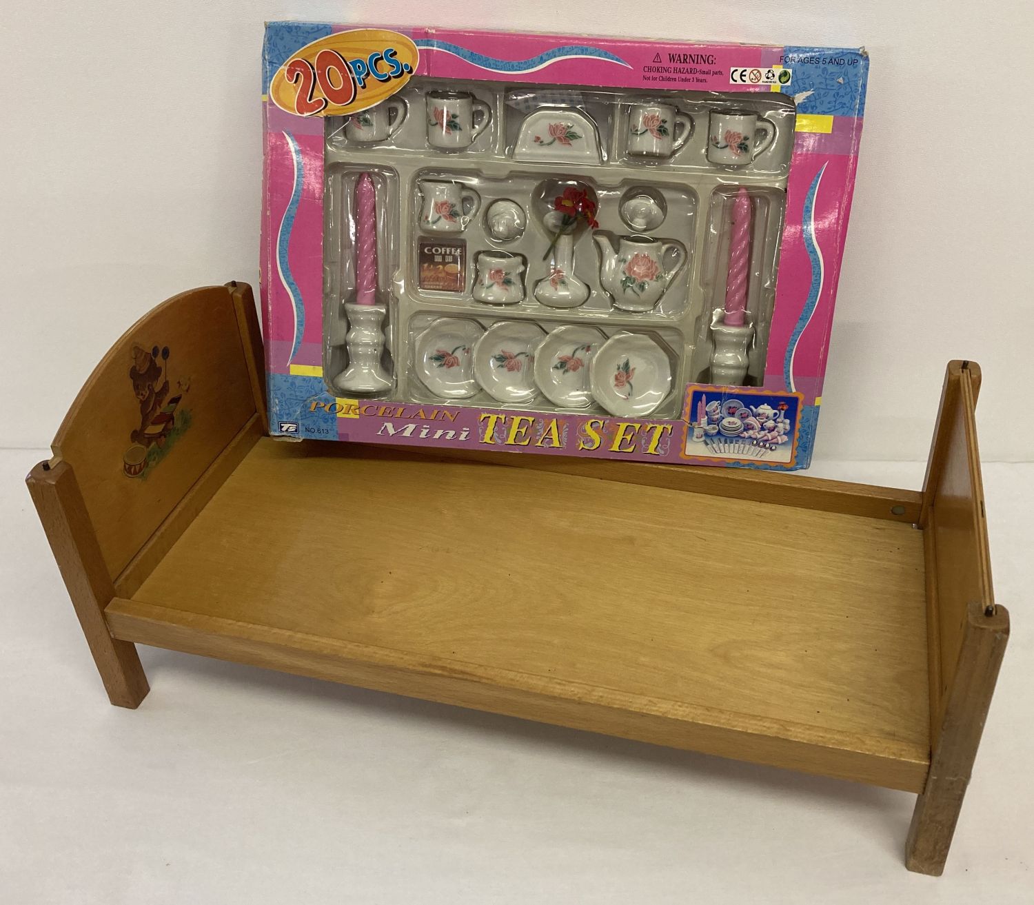 A vintage dolls bed with transfer detail to headboard.