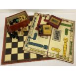 A box of vintage carved wooden chess board pieces with a Chad Valley folding chess board.
