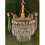 A vintage French style 2 tier brass and crystal chandelier with decorative brass leaf overhangs.