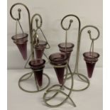A set of 3 metal framed candle holders with purple glass hanging candle holders.