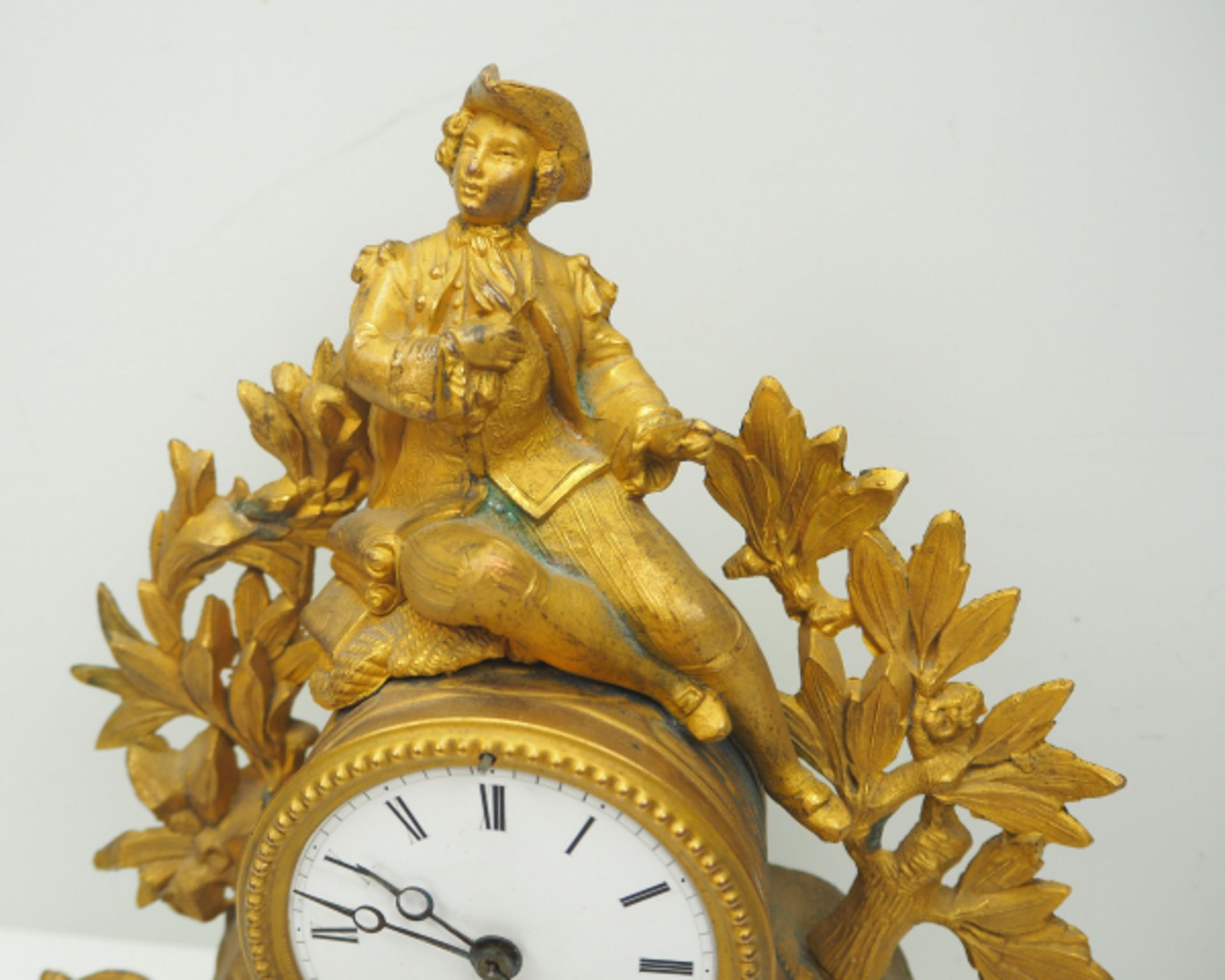 Kaminuhr.Vergoldetes Messinggehäuße, zentral sitztendes Uhrwehr, von einer Figur bekrönt. Auf - Bild 2 aus 3
