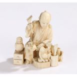 Japanese Meiji period ivory Okimono, carved as a daruma toy maker with tools and drawers