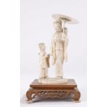 Japanese Meiji period ivory okimono, carved as a lady walking under her umbrella with a child to her