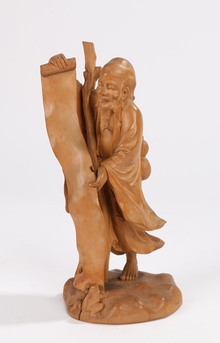 Japanese Meiji period boxwood carved okimono, of a standing scholar holding a long scroll, a toad to