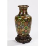 Chinese Cloisonné vase, decorated with colourful flower heads, 16cm high, raised on a carved