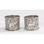 Pair of Indian white metal napkin rings, with pieced elephant, tiger and palm tree decorationNo
