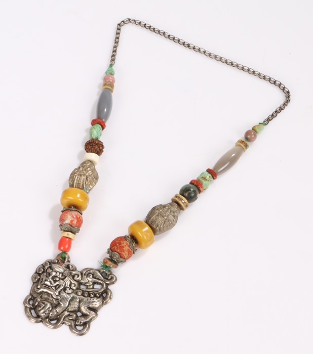 Tibetan necklace, with a dog of Foo pendant and a row of shaped and polished stones to the necklace,