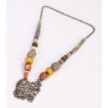 Tibetan necklace, with a dog of Foo pendant and a row of shaped and polished stones to the necklace,