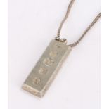 Silver ingot pendant, Queen Elizabeth II silver jubilee 1977, with scroll decoration, on a white