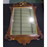 George III mahogany wall mirror, surmounted by a gilt bird above the rectangular mirror plate,