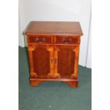 Yew wood stereo cabinet, the hinged lid above two cupboard doors with dummy drawer front, on bracket