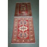 Pair of Middle Eastern style carpets, both with red grounds and geometric borders, 85cm and 80cm