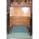 Walnut veneered bureau, the fall opening to reveal a pigeonholed interior, two long frieze