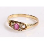 Gold coloured metal ring set with central ruby flanked by four diamond chips, ring size P, 2g