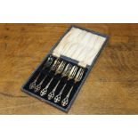 Set of six plated cake forks with pierced fleur-de-lys handles, housed in a fitted case