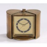 Europa travel alarm clock, the gilt metal oval case with engine turned and foliate decoration,