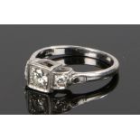 18 carat white gold diamond set ring, with a central diamond flanked by a diamond to either