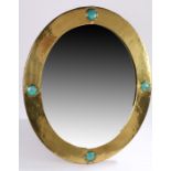 Ruskin style wall mirror, the beaten brass frame with four turquoise porcelain roundels and copper