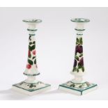 Near pair of Wemyss candlesticks, one example painted with plums and the other with cherries, the
