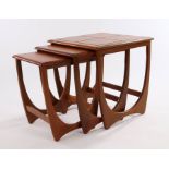 Nest of three G-plan teak occasional tables, the largest with tile inset top, raised on curved end