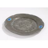 Arts and Crafts pewter dish, the beaten central field surrounded by a wavy border with two blue