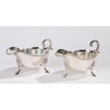 Pair of silver plated sauce boats, with double scroll handles and gadrooned rims, raised on shell