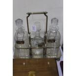 Plated tantalus containing three decanters and with three decanter labels for whiskey, brandy and