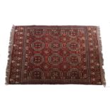 Tekke Turkoman Dozar carpet, the red ground with lozenge patterned centre and tasselled ends,
