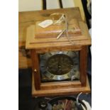 Comitti of London mantel clock, the brass dial with Roman numerals, housed in a wooden case, the
