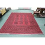 Middle Eastern carpet with black elephant feet design on a red ground, with tasseled ends, approx.