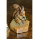 Squirrel paperweight, the painted metal squirrel holding a green acorn