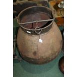 Substantial rivetted metal pot, with swing handle and bulbous lower section, 65cm high