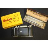 Hohner 64 Chromonica harmonica, housed in a maple effect case, Kodak Modele B11 camera, housed in