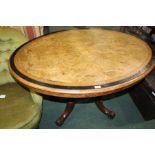 Victorian walnut and boxwood strung oval table, the tilt top raised on quadruple supports and