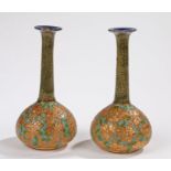 Pair of Royal Doulton stoneware vases, the ovoid gilt bodies incised with flowers on a green and