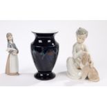 Two Lladro figurines depicting a lady and a boy with dogs, the boy 19cm high, together with a