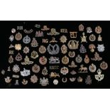 Collection of First and Second World War British army cap badges and shoulder titles, all with