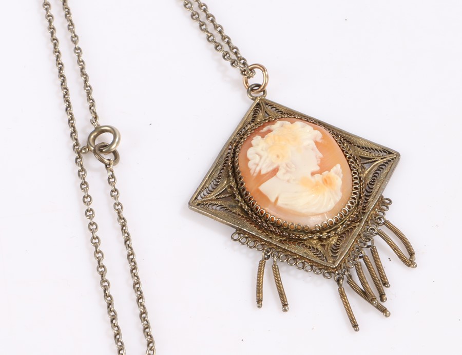 Cameo pendant, housed in a filigree mount and on a white metal necklaceLosses to hanging