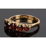 18 carat gold garnet set ring, with a row of five garnets, ring size M