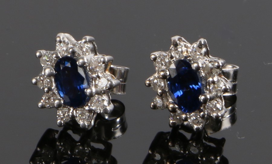 Pair of diamond and sapphire set ear studs, with a central sapphire and diamond surround to each,