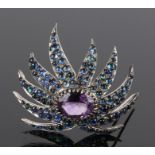 Sapphire and amethyst set brooch, the central amethyst with a sapphire leaf surround on white metal,