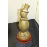 Novelty brass money pot as a penguin on a wooden plinth, 36cm high