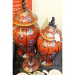 Two porcelain vases, in red and blue decoration, together with a spare lid