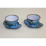 Pair of Chinese enamel cups and saucers, with flower design, the saucers 12.5cm diameter